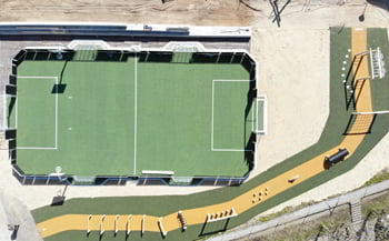 Udendørs bevægelsesmiljø med en multibane og en forhindringsbane med gummibelagt underlag.