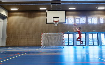 Loftmonterede motorbasketstativer, ribber og spærrenet til halopdeling på Skolen i Bymidten