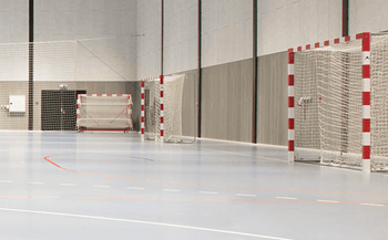 Indretning af idrætshallen med kvalitetsudstyr som håndboldmål, gulv opstregninger til håndbold og spærrenet fra A-Sport til moderne bevægelsesmiljø i Skive